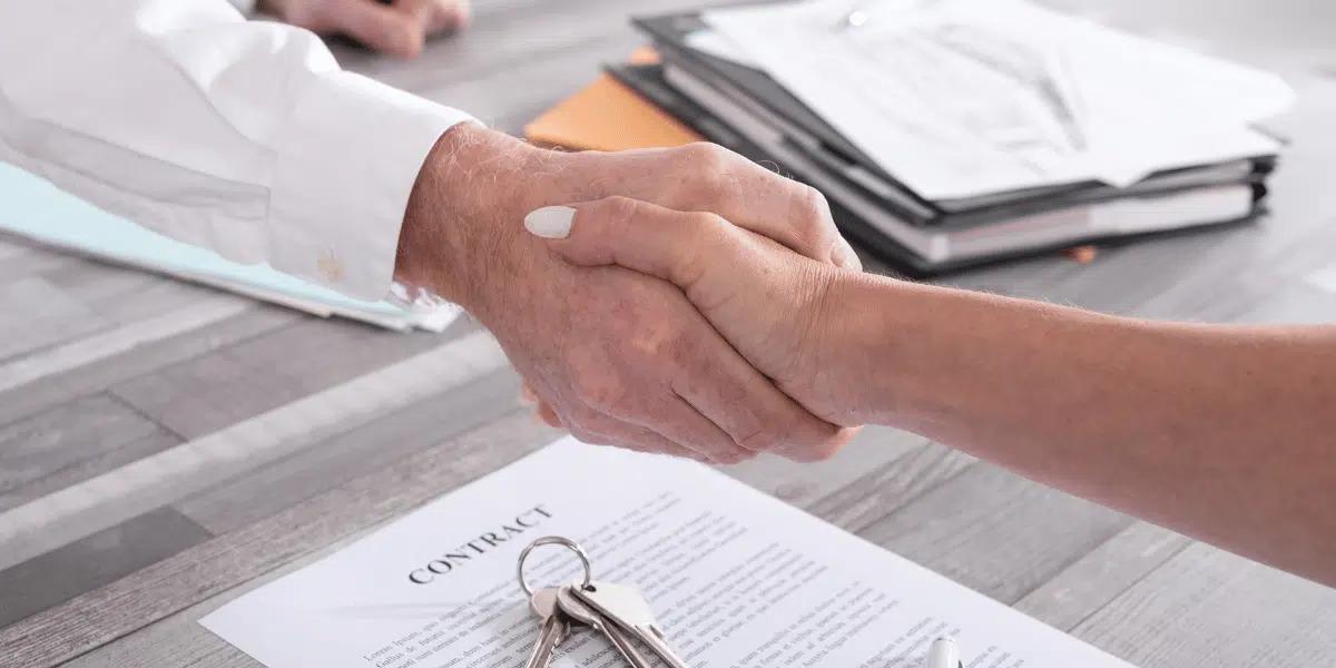 Two people shaking hands after completing a real estate transaction