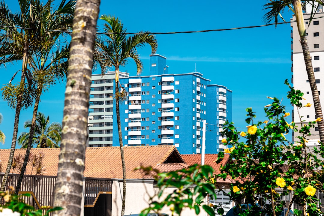 A bright, modern condominium balcony with a clear glass railing offers a stunning view of the ocean and beach, showcasing the convenient and stylish side of condo life in Cabo.