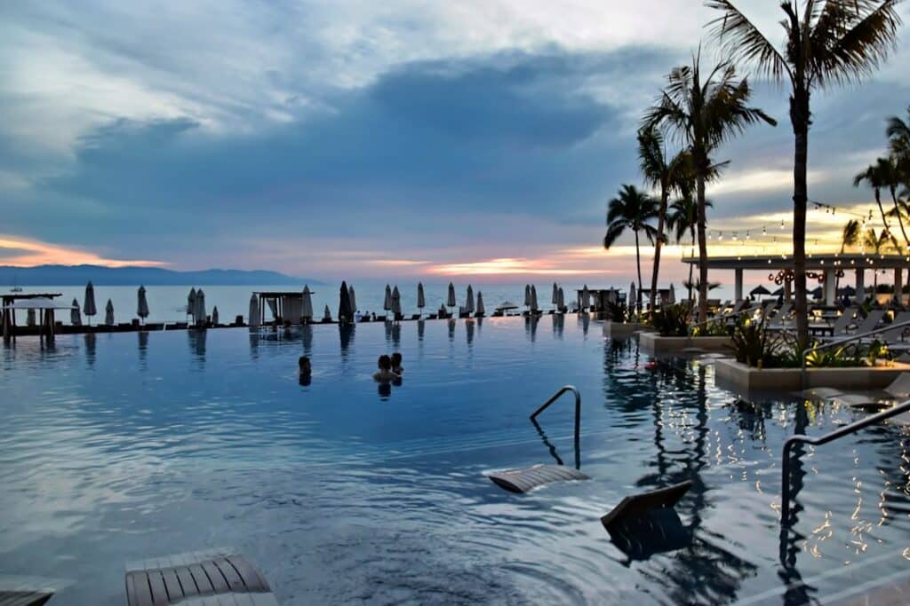 Stunning infinity pool at a luxury villa in Cabo San Lucas, Mexico, overlooking the turquoise ocean at sunset, representin...