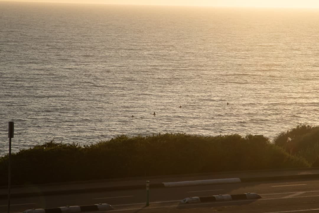 An elegant outdoor patio with comfortable lounge chairs overlooking a serene ocean sunset in Los Cabos, representing a tranquil lifestyle.