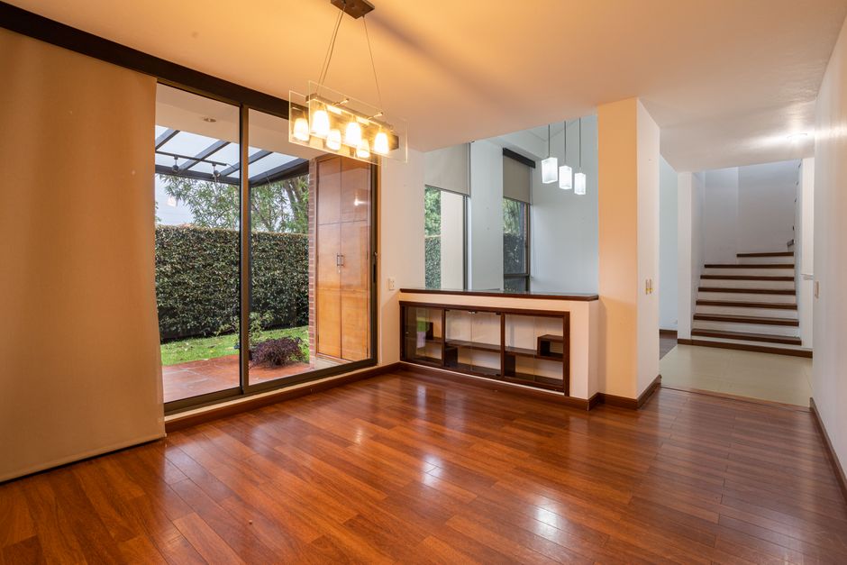 Bright, empty living room in a modern luxury home with large windows revealing a stunning ocean view, representing the sta...