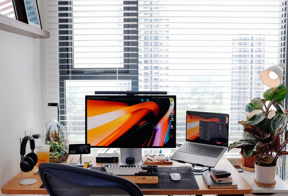 A bright, modern home office with a clean desk and chair perfectly positioned to look out a large window at a stunning ocean view.