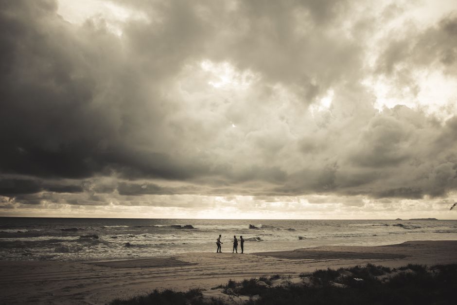 Dramatic view of a Cabo San Lucas beach with dark, stormy clouds gathering over the ocean, representing the potential chal...