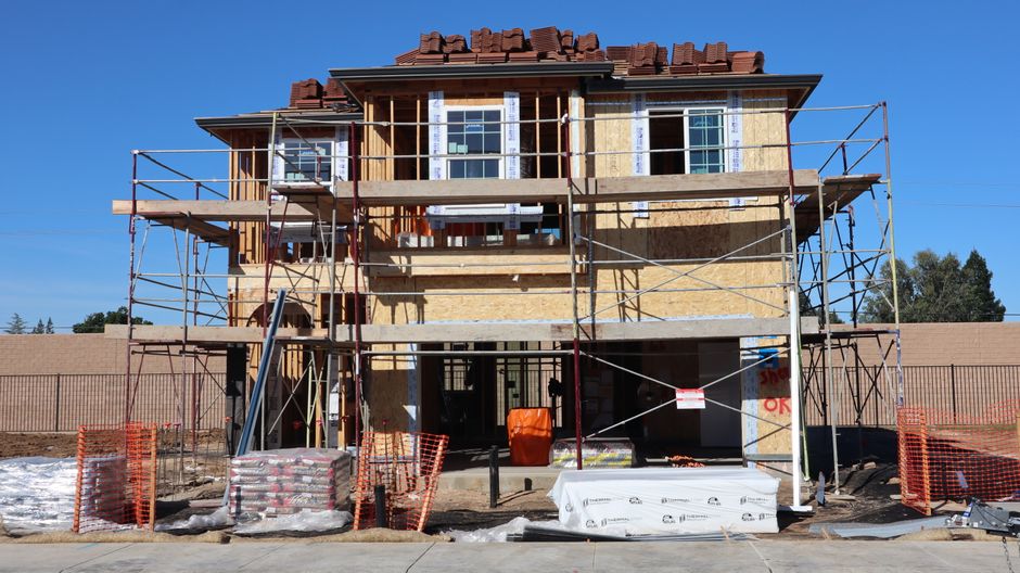 A modern architectural home in a desert landscape like Cabo under construction, symbolizing the process and potential hurdles of building a dream life abroad.