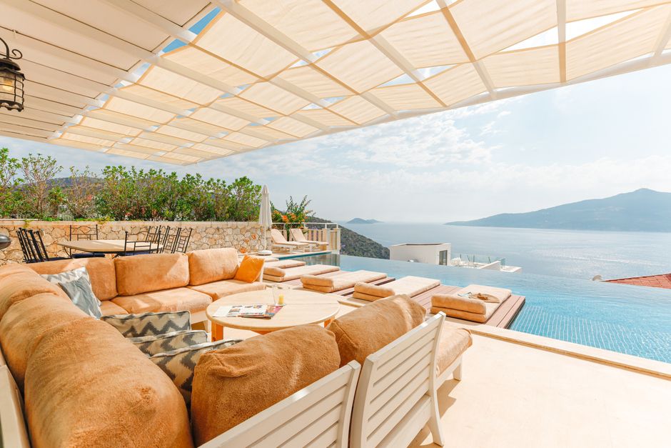 A stunning infinity pool at a modern luxury home in Cabo, with a clear view of the turquoise ocean and blue sky, representing the ideal paradise homeowners seek to protect.