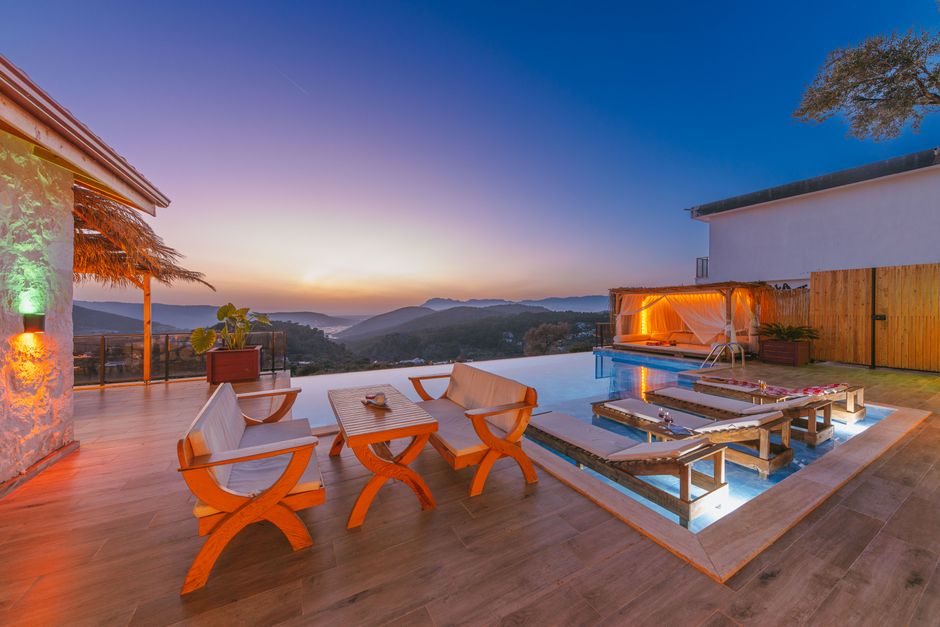 Stunning modern luxury villa in Cabo with a bright infinity pool overlooking the sparkling blue ocean under a clear sunny ...